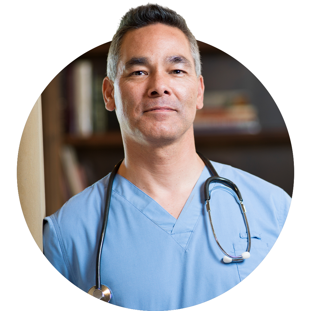 A confident doctor wearing blue scrubs with a stethoscope